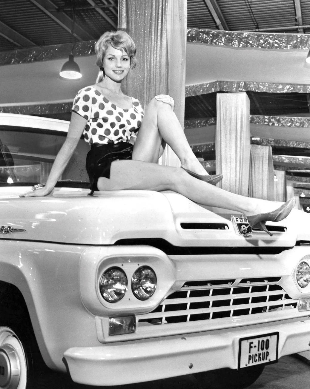 A model poses atop a Ford F-100 truck 